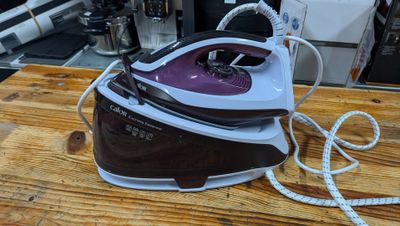 a brown and white steam iron sitting on a wooden table