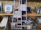 a ladder that is next to a shelf with pots and pans on it