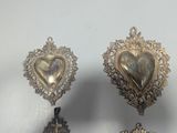 three pieces of silver metal with a heart on top of them