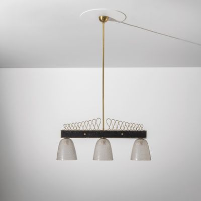 un lustre noir et blanc à trois lumières suspendu au plafond