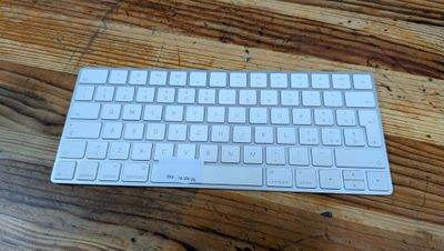 a white keyboard sitting on top of a wooden table