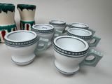 several cups and mugs are lined up on a table