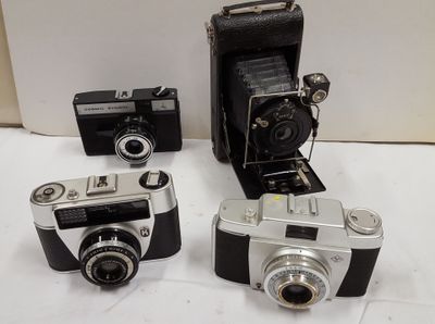 trois vieux appareils photo posés les uns à côté des autres sur une table