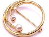 a close up of a brooch with pearls on a white background