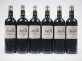 six bouteilles de vin sont alignées sur une surface blanche