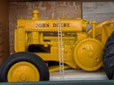 a yellow tractor that is on display in a room