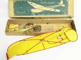un petit avion jouet jaune et rouge dans une boîte, à côté d'un autre petit avion jouet jaune et rouge