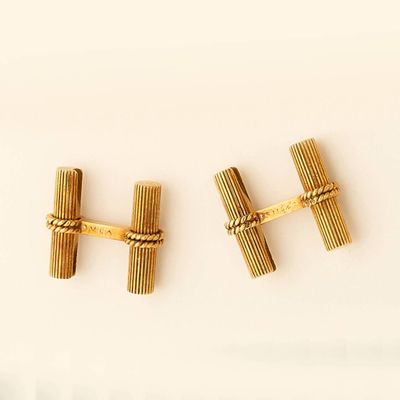 pair of gold tone cufflinks with a knot on each end