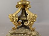 an image of a gold colored candle holder on a marble base