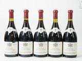 six bouteilles de vin sont alignées sur une surface blanche