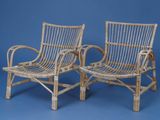 pair of wicker lounge chairs on a blue background