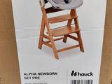 the box of the high chair has a baby seat in it