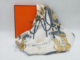 the white and gold scarf is next to an orange box
