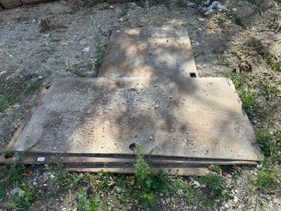une dalle de béton posée au sol, près d'une clôture