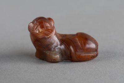 une petite figurine représentant un chien couché sur une table