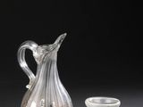 deux vases en verre et un petit verre posé sur une table