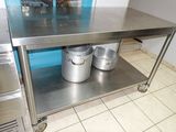 une table en acier inoxydable sur laquelle sont posés deux seaux