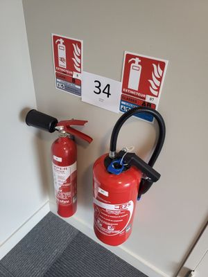 deux extincteurs accrochés au mur l'un à côté de l'autre