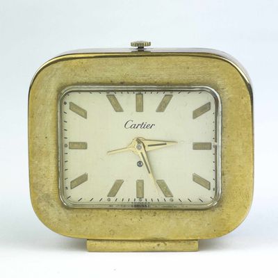 une horloge en or posée sur une surface blanche