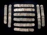 a close up of a bunch of silver coins on a black surface