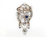 une broche ancienne sertie de diamants et de saphirs, sur fond blanc