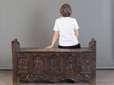Il y a quelqu'un assis sur un banc, vêtu d'une chemise blanche.