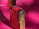 un briquet posé sur une surface rose