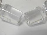 pair of clear glass salt and pepper shakers on a white surface
