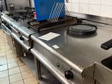 une cuisinière dans une cuisine, sur laquelle se trouve une boîte bleue