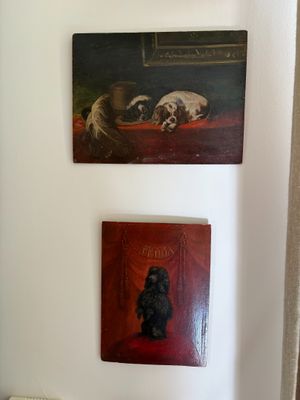 two paintings on the wall above a toilet in the bathroom