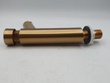 a brass plated pipe with a white cap on a white surface