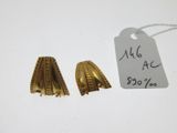 un gros plan sur une paire de boucles d'oreilles en or avec une étiquette de prix
