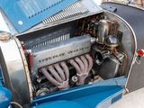 an old blue car with a engine in it ' s trunk