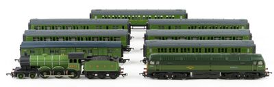 several green trains are lined up next to each other on a white surface