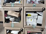 Plusieurs cartons contenant des articles divers sont empilés sur des palettes dans un entrepôt
