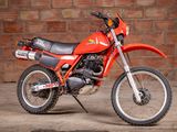a red dirt bike parked in front of a brick wall