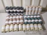 many rolls of yarn sitting on a table next to each other
