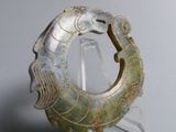 a green piece of art on display on a clear stand