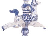 a blue and white figurine of a man riding a horse
