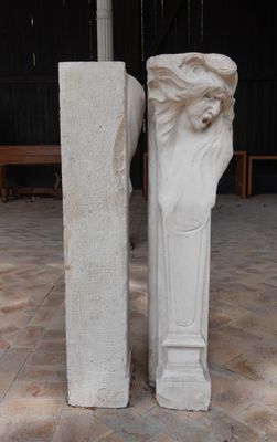 une statue représentant un homme barbu à côté d'un pilier