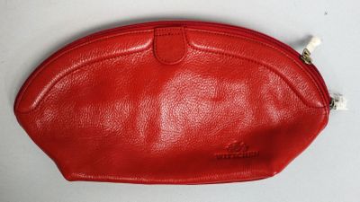 une image représentant un sac à main rouge posé sur une surface blanche