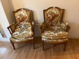 une paire de fauteuils avec des coussins rembourrés à motifs floraux dans un salon