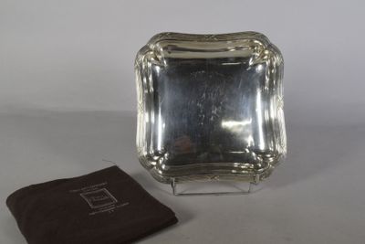 une petite assiette en argent recouverte d'un napperon marron sur la table
