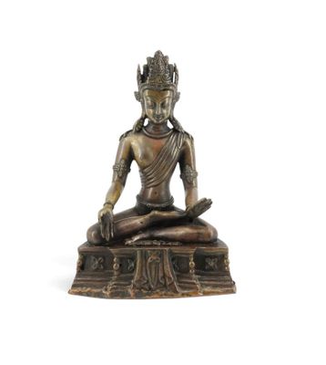 une statue en bronze représentant une personne assise en position du lotus