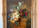 un tableau représentant des fleurs dans un panier, accroché au mur