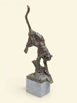 statue d'un chat debout sur un bloc, la patte posée sur le sol