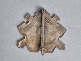 an image of a small metal pin with a gun on it