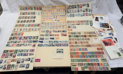 beaucoup de timbres posés sur une table, à côté d'une feuille de papier
