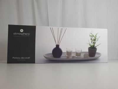 La boîte est ouverte sur la table ; elle contient des bougies et une plante.
