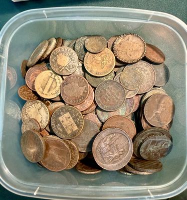un récipient en plastique rempli d'une multitude de pièces de monnaie posé sur une table